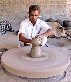 Indian modern age potter using wheel for making pottery items