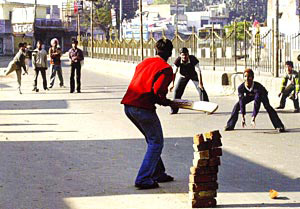 Youth Playing Cricket on Street